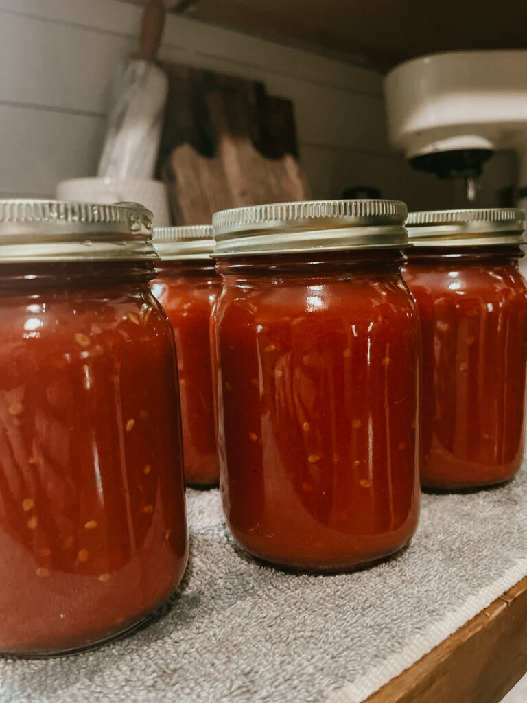 A jar of homemade jam with a canning kit in the background