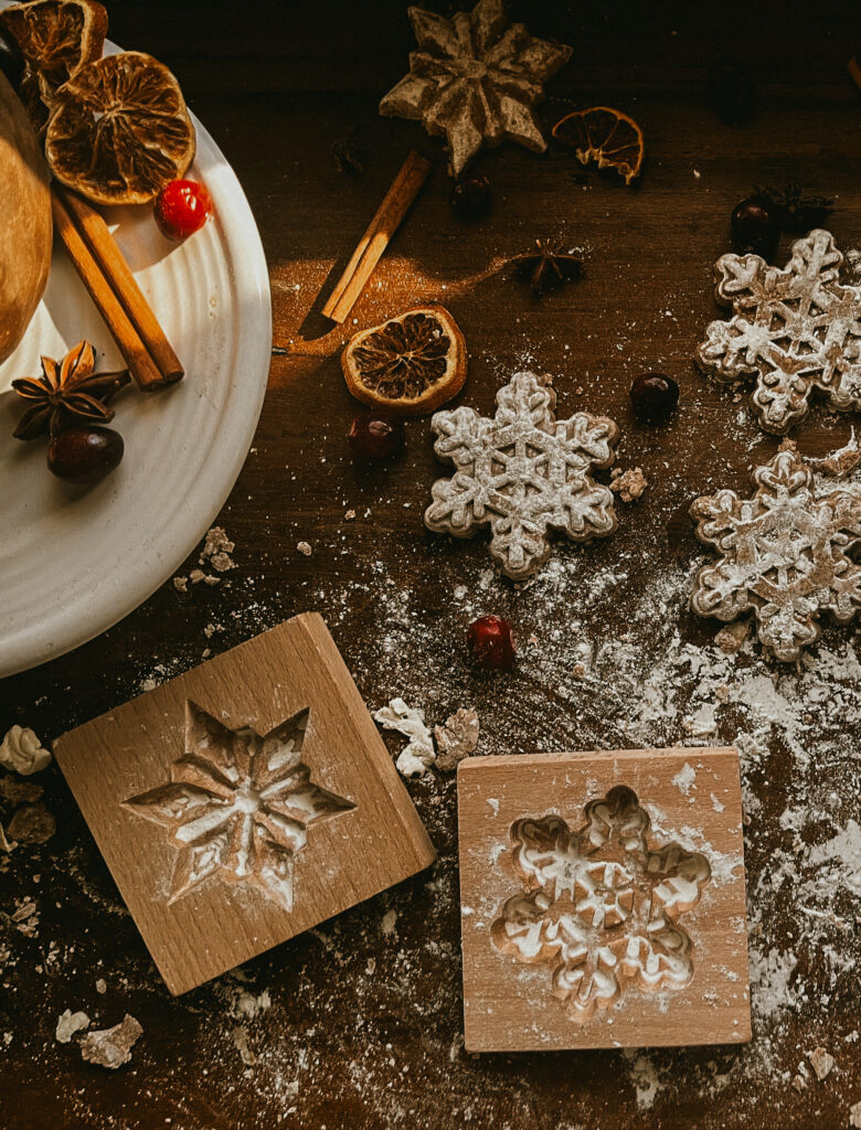 Close-up of a wooden cookie press stamping intricate patterns into dough